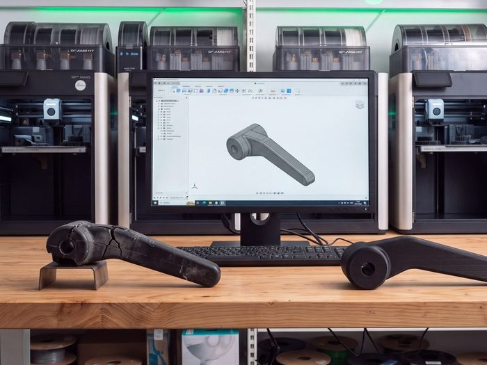Digitální model dílu na monitoru a skutečné díly na pracovním stole